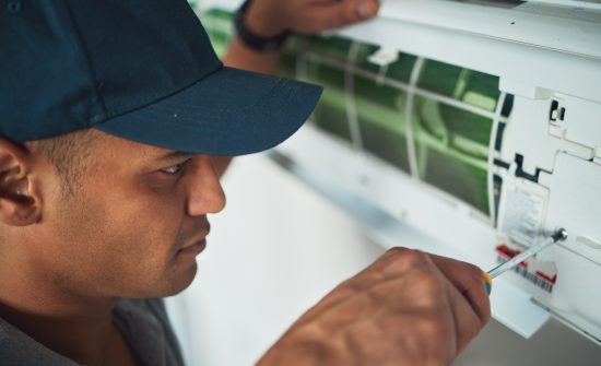 Face, hand and a man for aircon repair or maintenance in an office for circulation or central heati